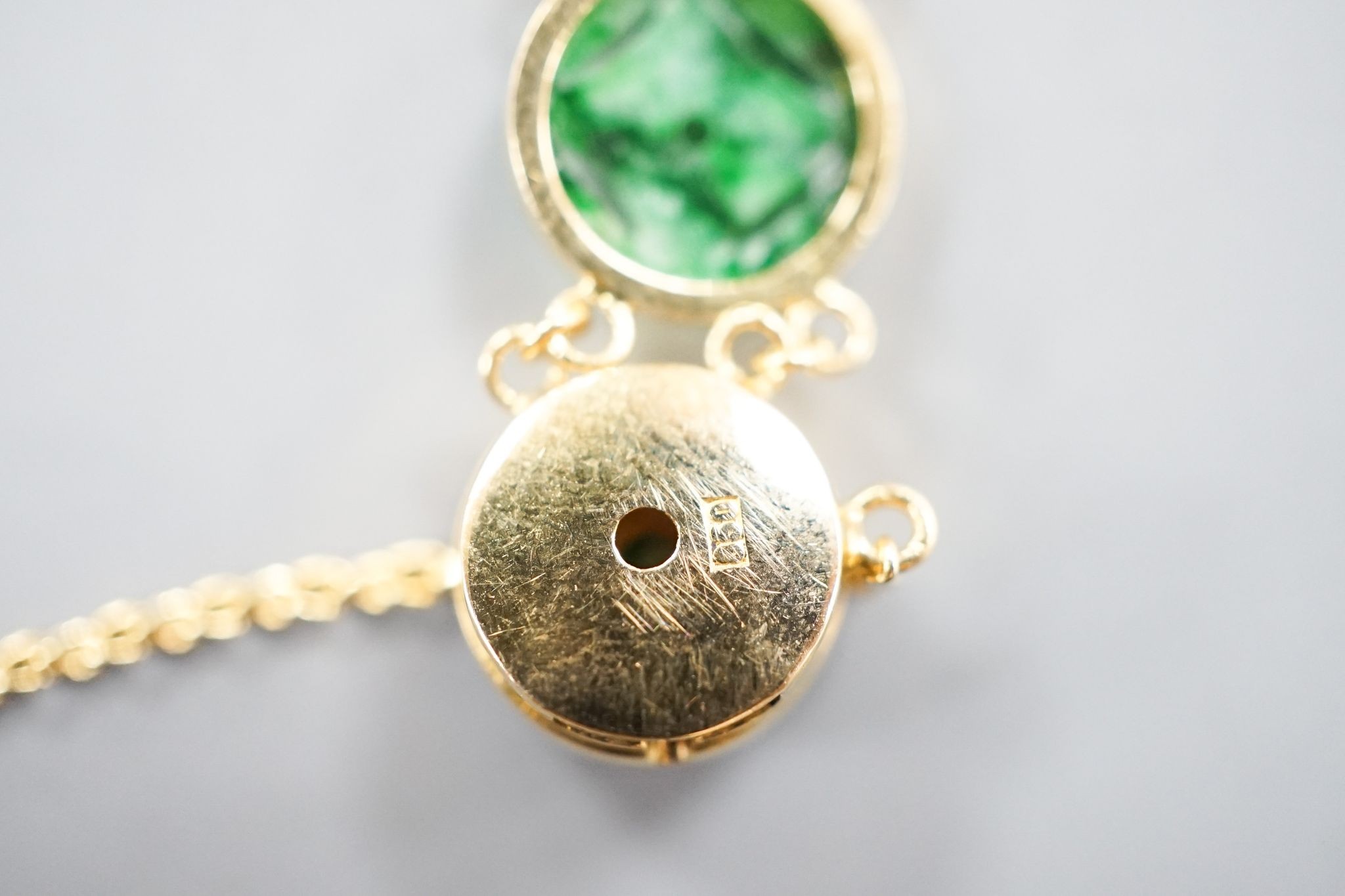 A Chinese 850 yellow metal and jade disc bracelet, 15cm and a matching small pendant, gross 9.7 grams.